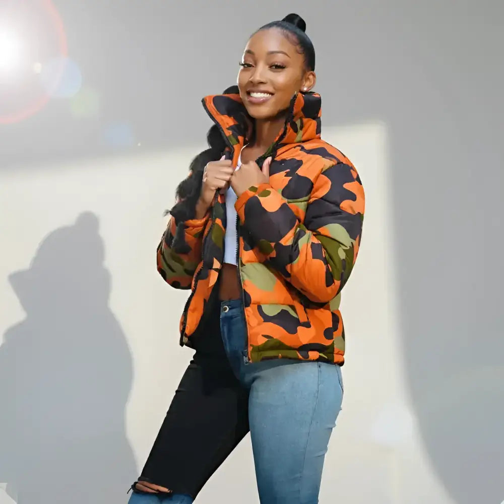 Femme portant un parka imperméable femme orange, noir, vert et jeans bicolores