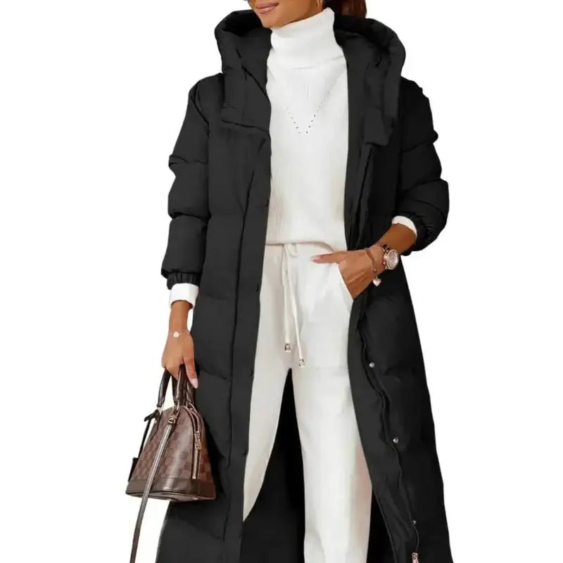 Parka longue femme kaki matelassée portée par une femme avec un haut blanc et un pantalon clair.