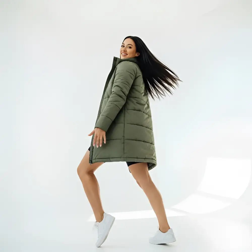 Parka longue femme kaki matelassée portée par une femme, style décontracté, sur fond blanc.