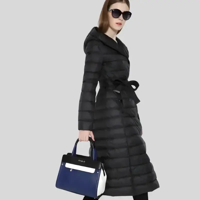 Parka capuche femme élégante et chaude portée avec un sac, parfaite pour l'hiver.