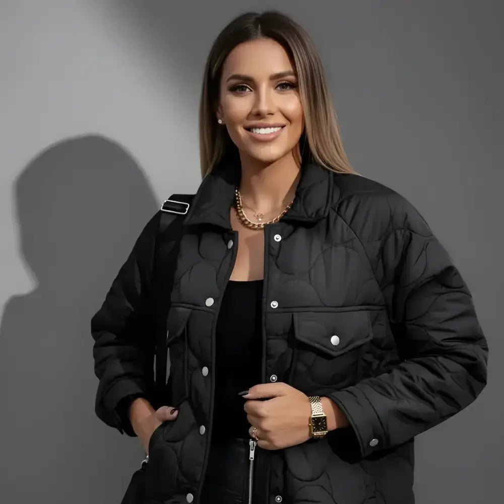 Parka femme courte matelassée noire portée par un modèle souriant, parfaite pour l'hiver.