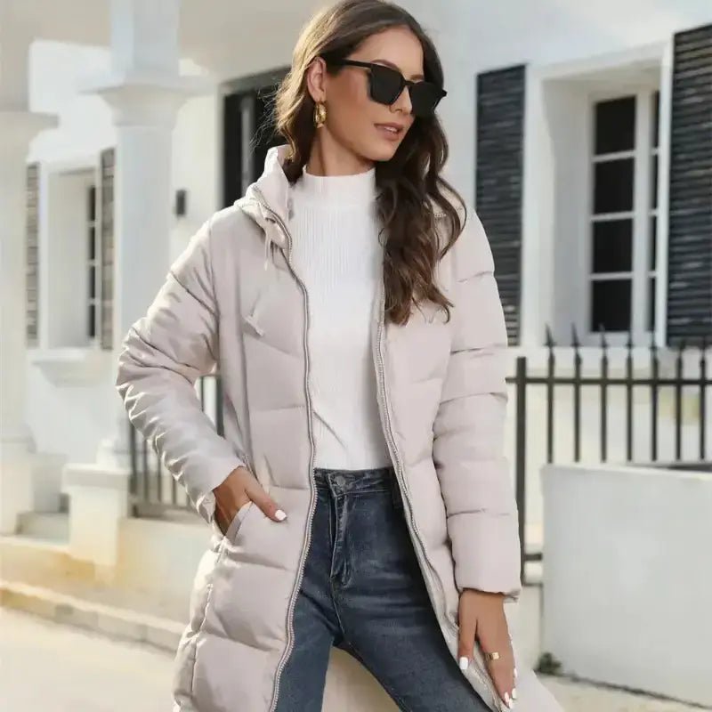 Parka femme longue imperméable chaude portée par une femme, avec capuche et lunettes de soleil.