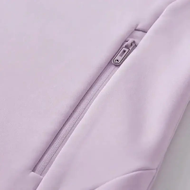 Détail de la fermeture éclair sur une parka femme à capuche cintrée, couleur rose.