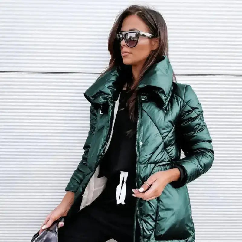 Parka femme matelassée brillante en vert portée avec lunettes de soleil élégantes.