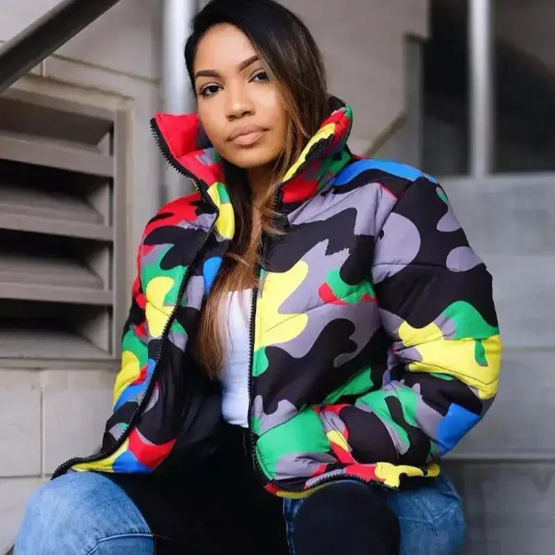 Parka femme camouflage à capuche colorée portée par une femme assise sur des escaliers.
