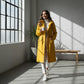 Femme portant un parka K-Way Femme jaune avec mug blanc, style imperméable