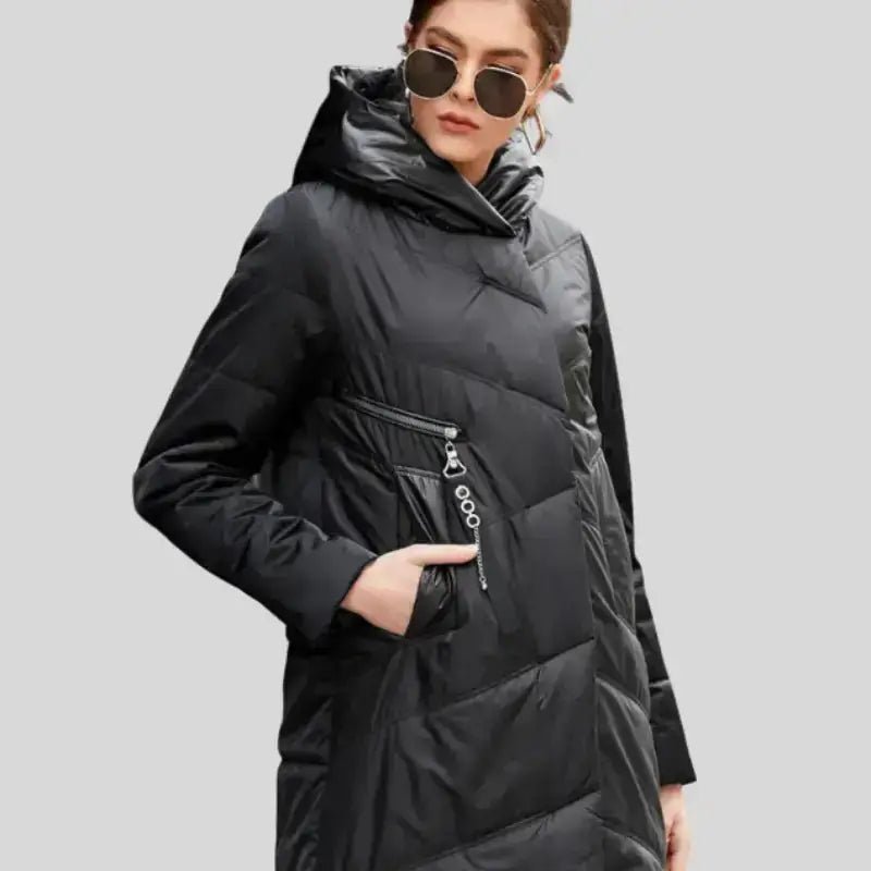 Parka longue femme matelassée à capuche couleur noire avec poches et lunettes de soleil.