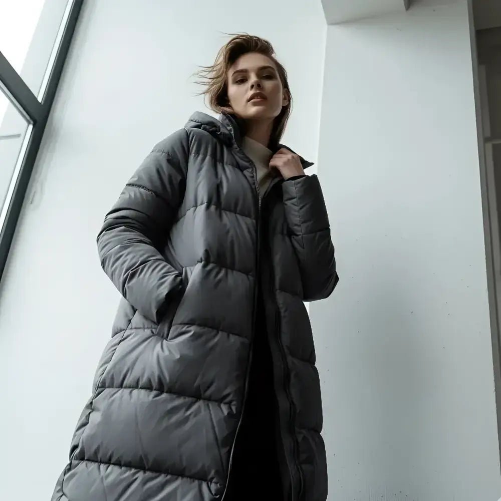 Parka longue femme matelassée, modèle gris, idéale pour les journées fraîches avec capuche et coupe confortable.