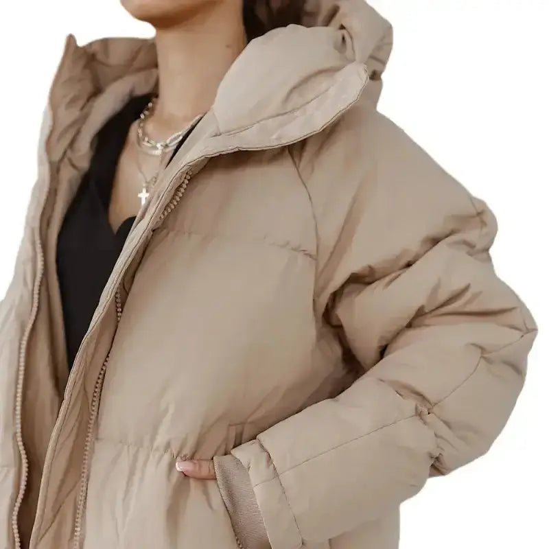 Parka femme longue beige avec capuche et coupe matelassée, parfaite pour l'hiver, offrant chaleur et confort.